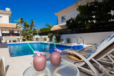 a patio table with two mardi gras decorations on it at Villa Malama in Paralimni