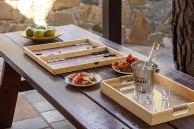 a table with a tray of fruit and a bottle of wine at Platres Forest View Cottage in Platres