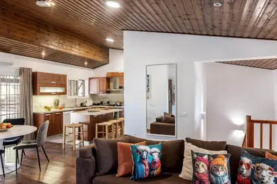 a living room and kitchen with a couch and a table at Platres Forest View Cottage in Platres