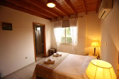 a bedroom with a bed with a lamp and a window at Swimmers' Paradise in Pissouri