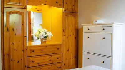 a bedroom with a dresser and a vase of flowers at Swimmers' Paradise in Pissouri