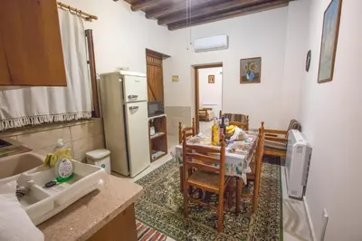 a kitchen and dining room with a table and a refrigerator at Iosiphis Stonebuilt House in Pano Lefkara