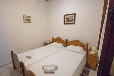 a bedroom with a bed with two white sheets at Iosiphis Stonebuilt House in Pano Lefkara