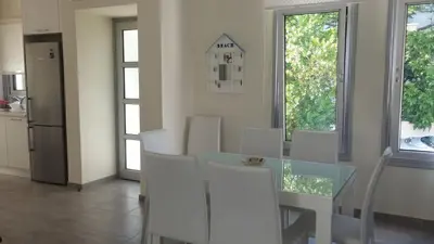 a dining room with a glass table and white chairs at FAMILY HOME in Protaras