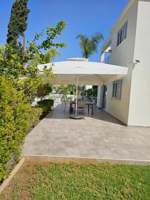 a patio with a white umbrella and a table at FAMILY HOME in Protaras