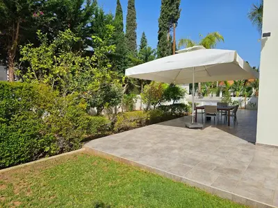a patio with a table and an umbrella at FAMILY HOME in Protaras