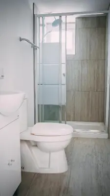 a white bathroom with a toilet and a shower at Midtown Napa Apartments in Ayia Napa