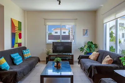 a living room with two couches and a tv at Villa Nova in Protaras