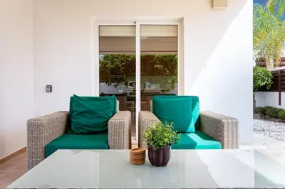 a patio with two chairs and a table at Villa Nova in Protaras