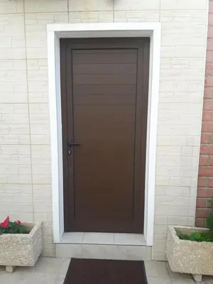 a brown door on a white brick building at Nicosia Luxury Studio in Nicosia