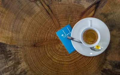 a cup of coffee and a book on a table at Island Boutique Hotel in Larnaka