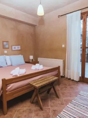 a bedroom with a large bed and a bench at Kardama HideAway in Kato Amiandos