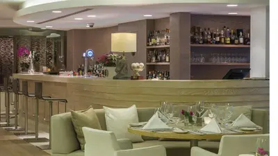 a dining room with a table and a bar at Alasia Boutique Hotel in Limassol
