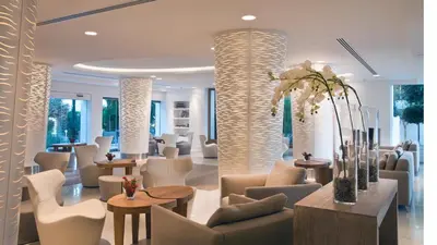 a lobby with white chairs and tables and a waiting room at Alasia Boutique Hotel in Limassol