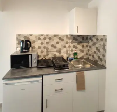 a kitchen with a sink and a microwave at Napa City Apartments in Ayia Napa