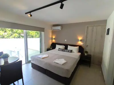 a bedroom with a bed and a table and a window at Napa City Apartments in Ayia Napa