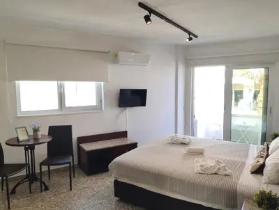a bedroom with a bed and a table and chairs at Napa City Apartments in Ayia Napa