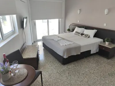 a bedroom with a large bed with a table and a tableablish at Napa City Apartments in Ayia Napa