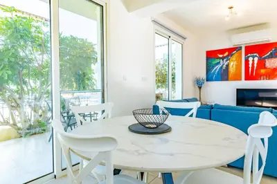 a living room with a table and chairs and a couch at Villa Francesca in Paralimni