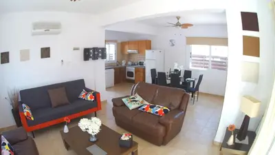 a living room with a couch and a table at Villa Sunrise in Paralimni
