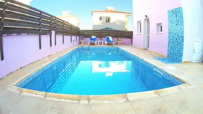 a swimming pool with blue water in a building at Villa Sunrise in Paralimni