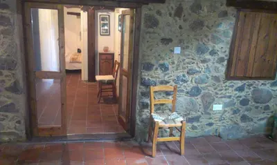 a room with two wooden chairs and a stone wall at Patriko Traditional House in Kakopetria