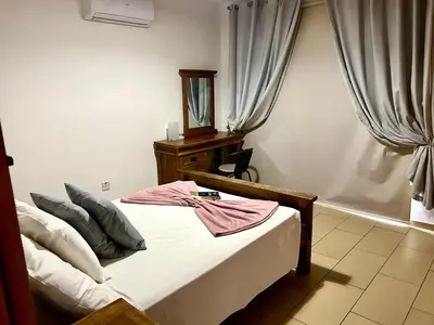 a bedroom with a bed and a mirror and curtains at Nissi Sandy Bay C09 in Ayia Napa