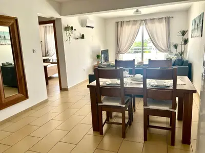 a living room with a dining room table and chairs at Nissi Sandy Bay C09 in Ayia Napa