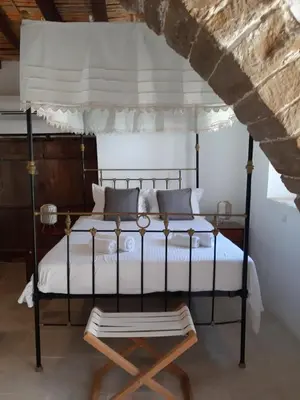 a bedroom with a canopy bed and a chair at Saint Antonio Maroni in Maroni
