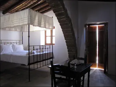 a bedroom with a canopy bed and a table with a chair at Saint Antonio Maroni in Maroni