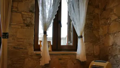 a window with white curtains in a stone room at Haven in Limassol