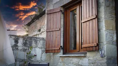 a window with wooden shutters on a stone building at Haven in Limassol