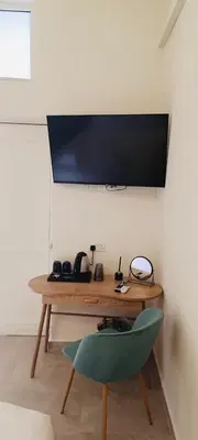 a desk with a green chair and a tv on a wall at Limassol Old Town Mansion in Limassol