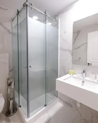 a bathroom with a glass shower and a sink at Limassol Old Town Mansion in Limassol