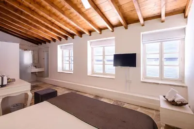 a living room with white walls and windows at Limassol Old Town Mansion in Limassol
