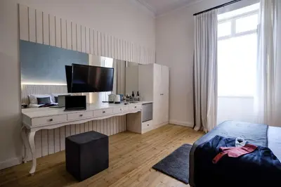 a bedroom with a bed and a desk with a television at Limassol Old Town Mansion in Limassol