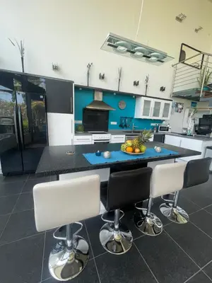 a kitchen with a table and two bar stools at VILLA CATALEYA Fig Tree Bay Protaras Town Center in Protaras