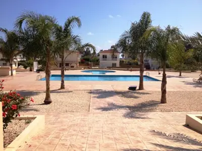 a swimming pool with palm trees in a yard at Nissi 3 C4 Pool View Apt in Ayia Napa