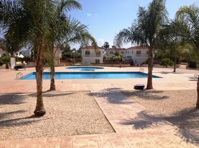 a swimming pool with palm trees around it at Nissi 3 C4 Pool View Apt in Ayia Napa