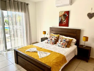 a bedroom with a bed and a large window at Nissi 3 C4 Pool View Apt in Ayia Napa