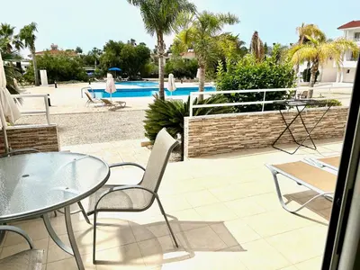 a patio with a table and chairs and a pool at Nissi 3 C4 Pool View Apt in Ayia Napa
