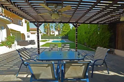 a patio with a blue table and chairs and a ceiling fan at Villa Daryah Sirina Bay in Protaras