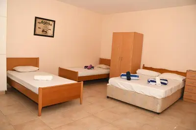 a room with two beds and a cabinet at Villa Daryah Sirina Bay in Protaras