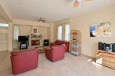 a living room with two red couches and a fireplace at Villa Daryah Sirina Bay in Protaras