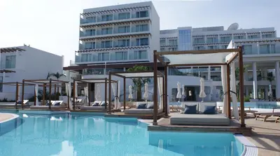a swimming pool with lounge chairs and a hotel at Sunrise Pearl Hotel & Spa in Protaras