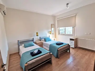 a bedroom with two beds and a window at Orchard Blossom Private Villa With Pool in Phrenaros