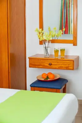 two oranges on a plate on a table in a bedroom at Paloma Hotel Apartments in Ayia Napa