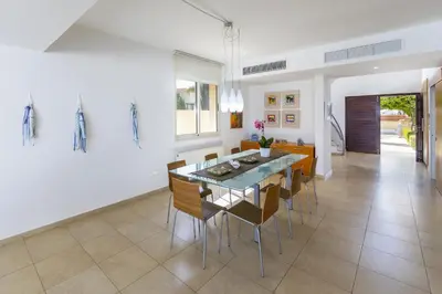 a dining room and kitchen with a table and chairs at Protaras Beachfront Villa Pietra in Protaras