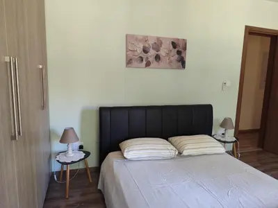 a bed with a black headboard and two tables with lamps at Roses Villa in Trimiklini