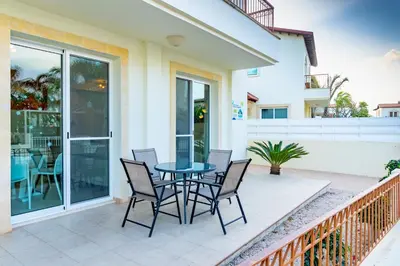 a patio with a table and chairs on a balcony at Villa Rosita in Paralimni